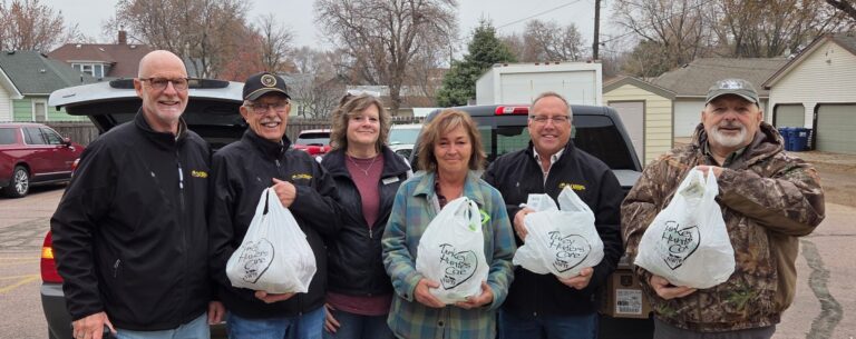Group holding food donation bags.